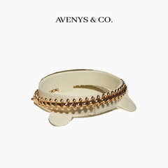 AVENYS & CO. Rivet Bangle in Yellow Gold, 17cm, with a plain studded metal pattern and no stones, shown on a display holder. Cutout from the original product photograph.