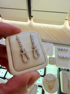 Original owner reference — White Gold U Link Drop Earrings in the foreground. Background jewellery and the display holder are not included.